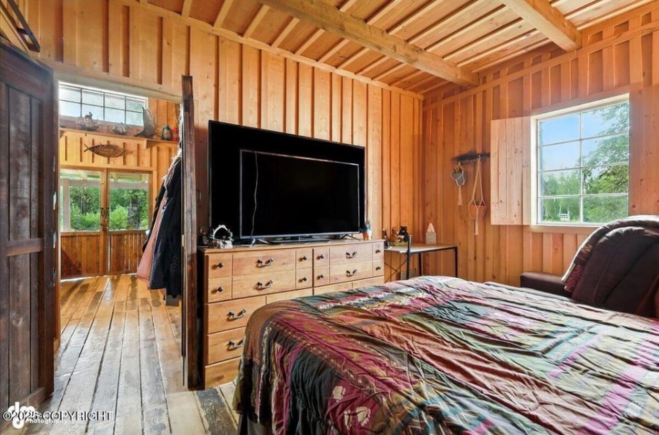 Bedroom with TV and wood paneling